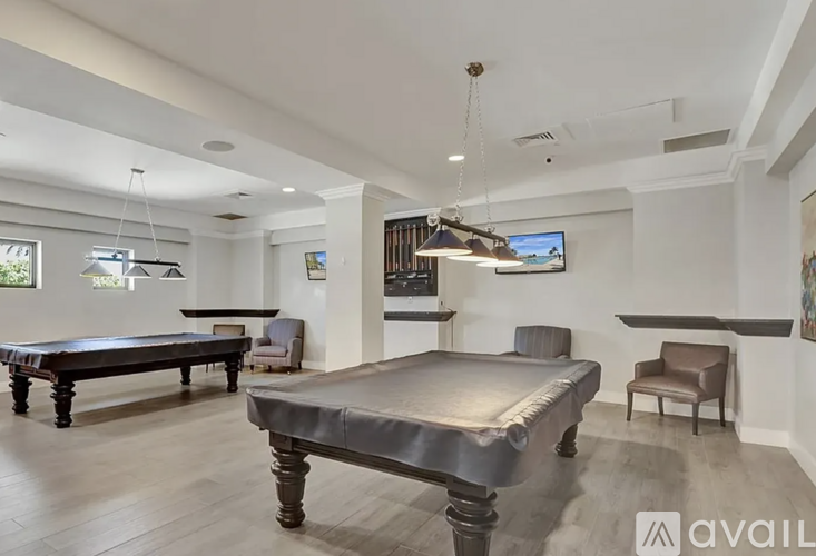 A room with a pool table and a television mounted on the wall.