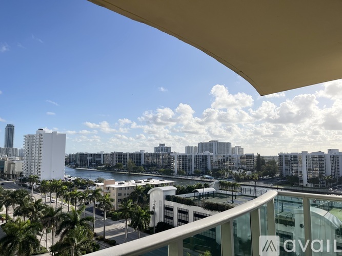 A view from a balcony overlooking a cityscape with palm trees.