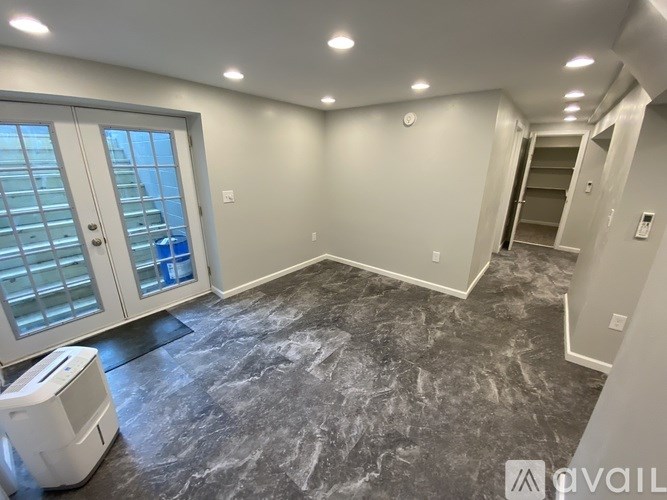 A room with a marble floor and a window with a view of a building outside.