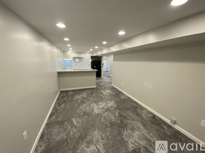 A long hallway with marble flooring and white walls.