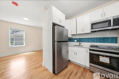 A kitchen with a refrigerator, oven, and cabinets.