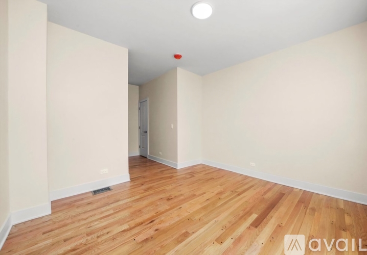 A room with wooden flooring and a white wall.