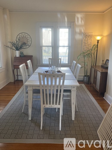 A dining room with a white table and chairs.