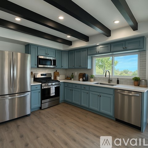 A modern kitchen with wooden floors and a large window.