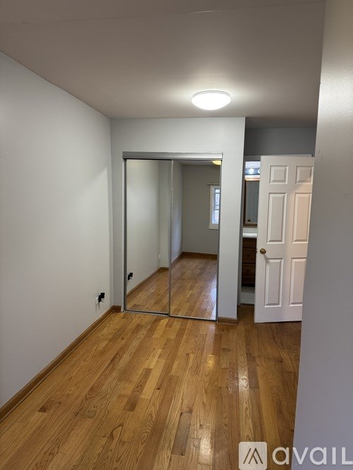 A room with a wooden floor and a white door.