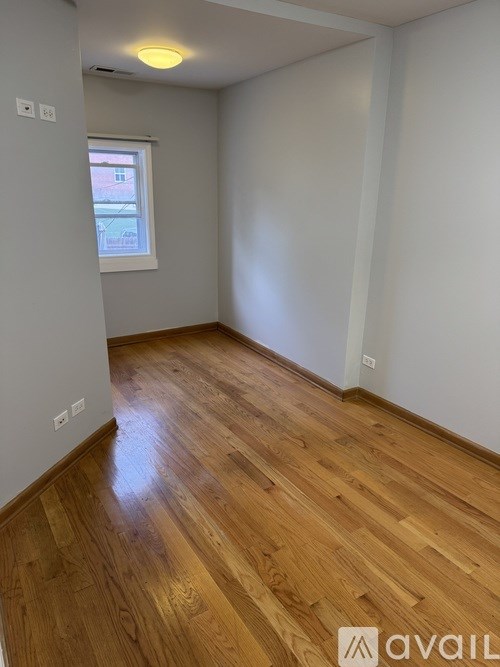 A room with wooden flooring and a window.