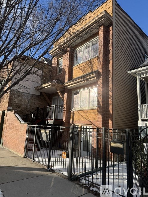 A brown building with a black gate in front.