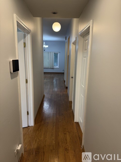 A hallway with a light on the ceiling and a camera on the wall.