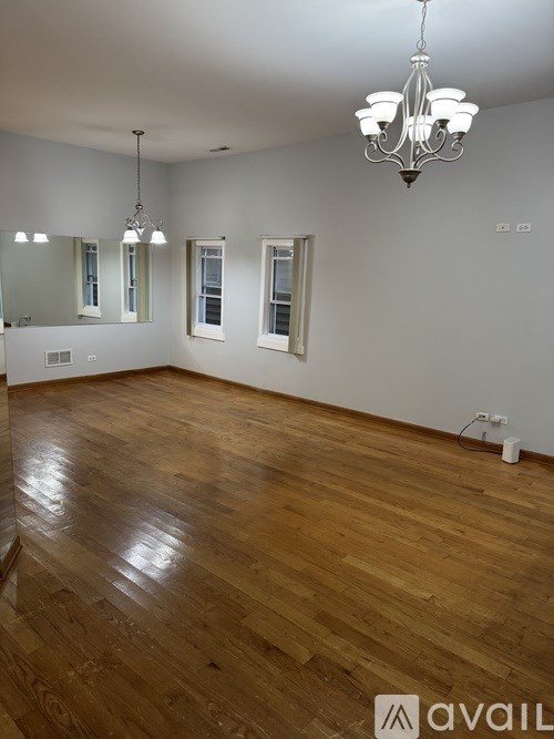 A room with wooden floors and a chandelier.