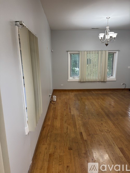 A room with wooden floors and a chandelier.