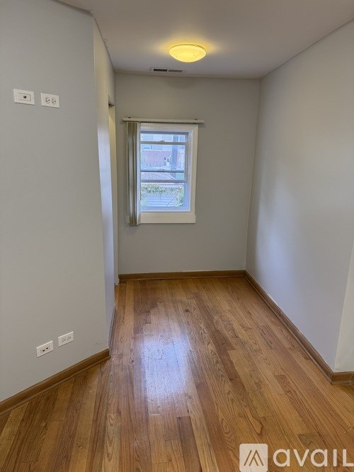 A room with wooden flooring and a window.