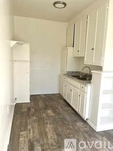 A kitchen with white cabinets and a granite countertop.