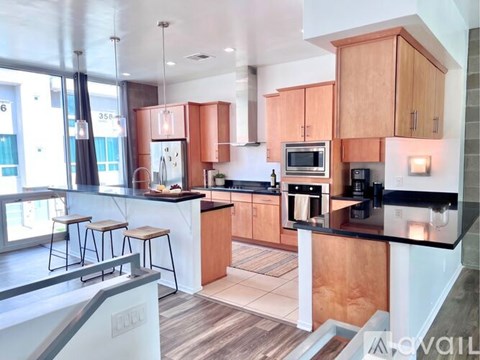 A modern kitchen with wooden cabinets and black countertops.