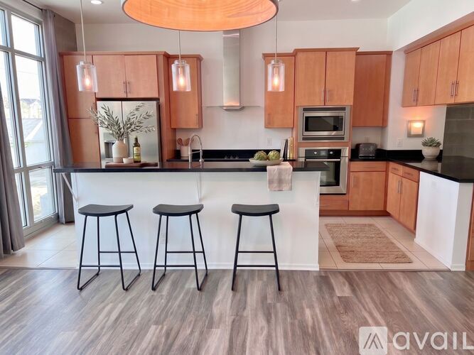 A kitchen with wooden cabinets and a black countertop.