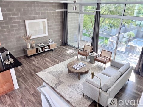 A spacious room with a staircase and a ceiling fan.