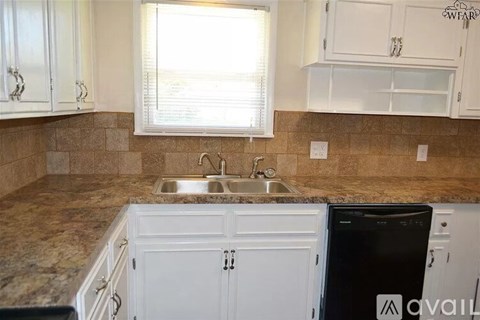 A kitchen with a black dishwasher and a sink.