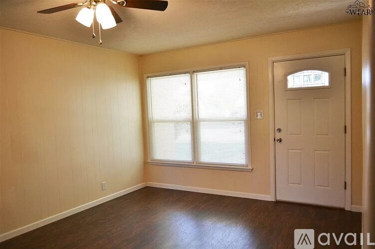 A room with a ceiling fan and a door.