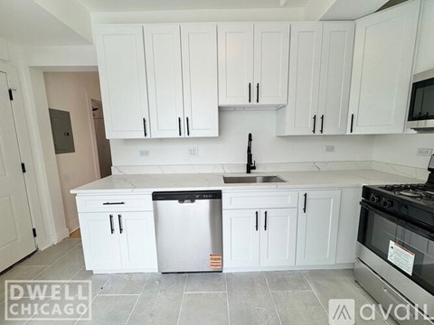 A kitchen with white cabinets and a stainless steel refrigerator.