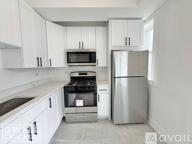A kitchen with white cabinets and a white sink.
