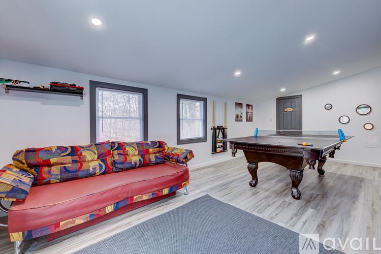A room with a pool table and a couch.