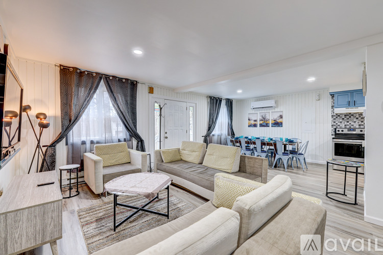 A spacious living room with a sofa set, a coffee table, and a dining table with chairs.