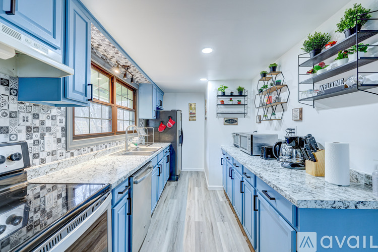 A kitchen with blue cabinets and a marble countertop.