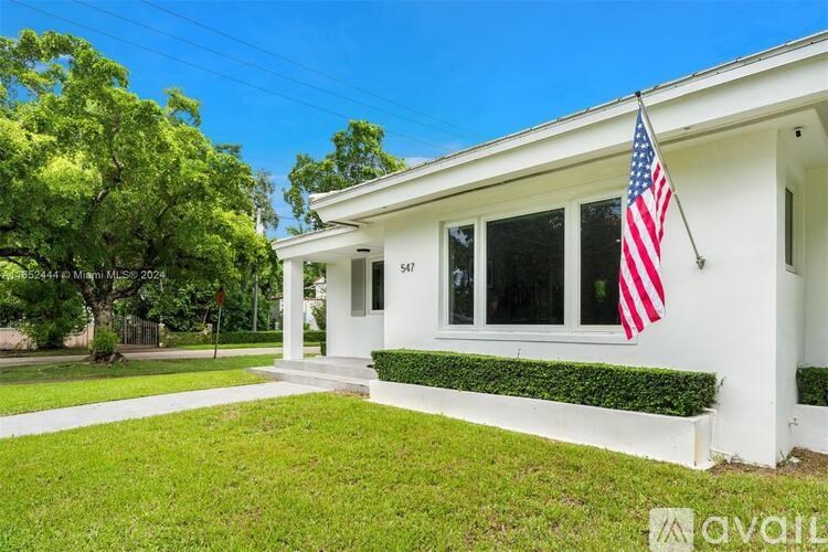 A white house with a flag on the front porch.