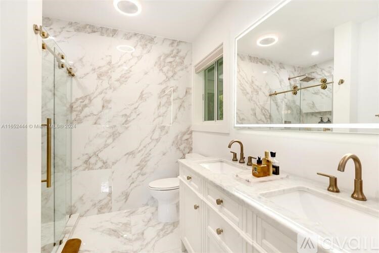 A bathroom with marble walls and a white vanity.