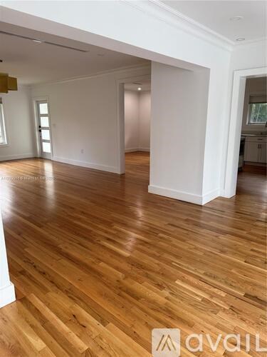 A room with wooden flooring and white walls.