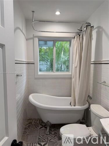 A white bathroom with a bathtub, toilet, and sink.