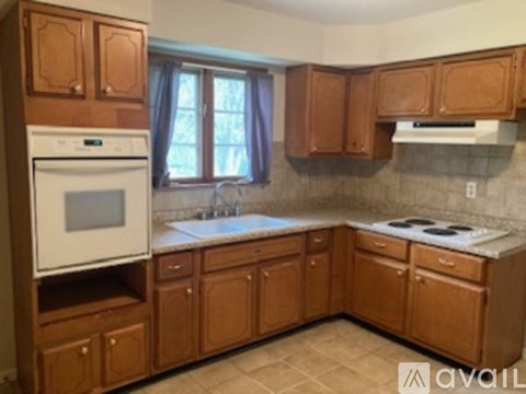 A kitchen with wooden cabinets and a white dishwasher.