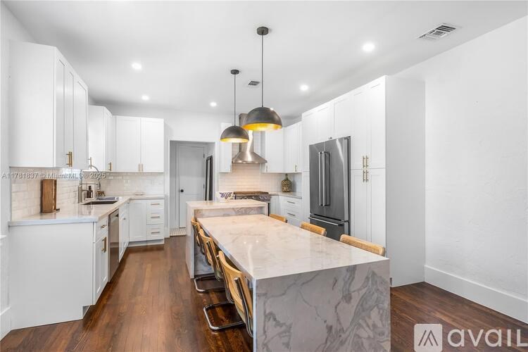 A modern kitchen with white cabinets and a central island.