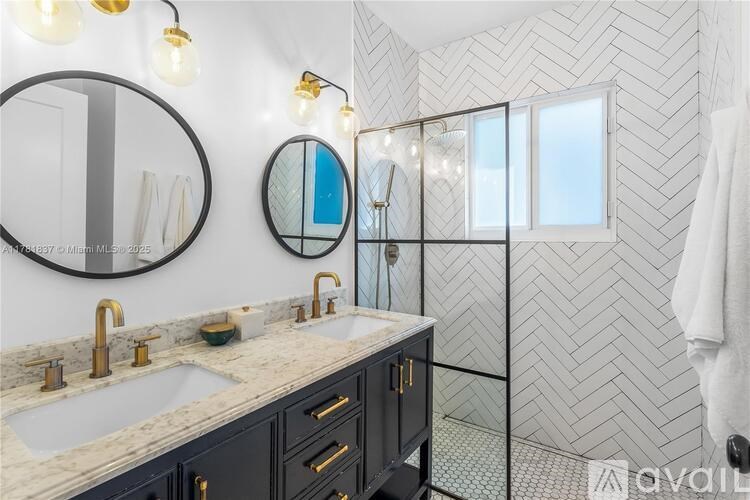 A bathroom with a marble countertop and a glass shower enclosure.