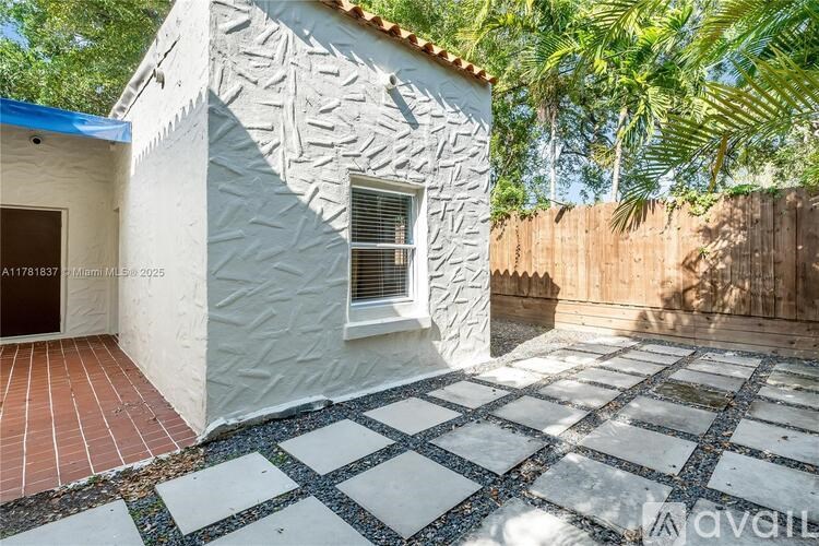 A white house with a patterned wall and a tiled floor.