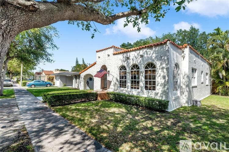 A white building with a red roof and a flag on it.