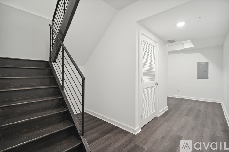 A staircase with a metal railing leads up to a white door.