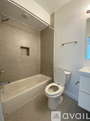 A bathroom with a toilet, tub, and towel rack.