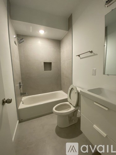 A white bathroom with a toilet, sink, and bathtub.