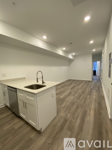 A kitchen with white cabinets and a sink is available for rent.