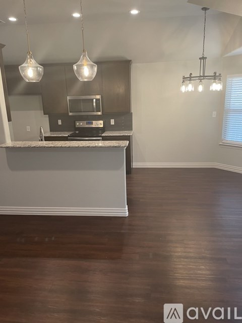 A kitchen with a white countertop and brown flooring.