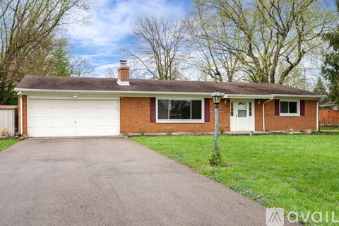 A house with a white garage door and a brick facade.