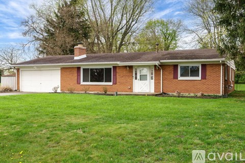 A brick house with a white garage door and a brown roof.