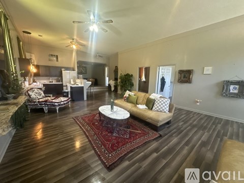 A living room with a red rug and a white coffee table.
