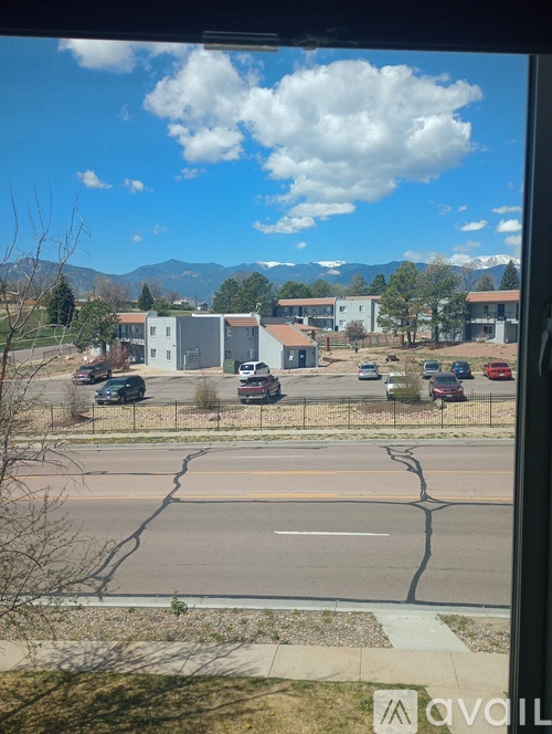 A view from a window of a street with cars and buildings.