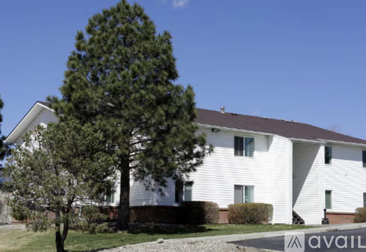 A white house with a tree in front of it.
