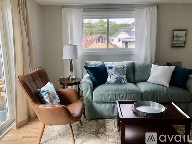 A living room with a brown leather chair and a green couch.