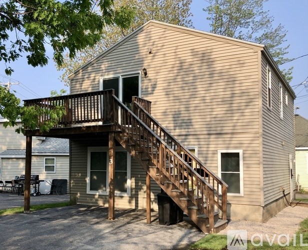 A house with a wooden deck and stairs leading to the entrance.