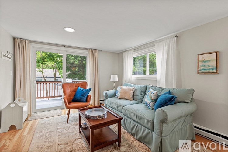 A living room with a couch, chair, and window.