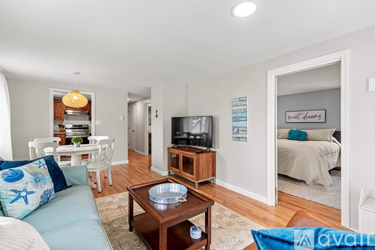 A living room with a sofa, a coffee table, and a television.