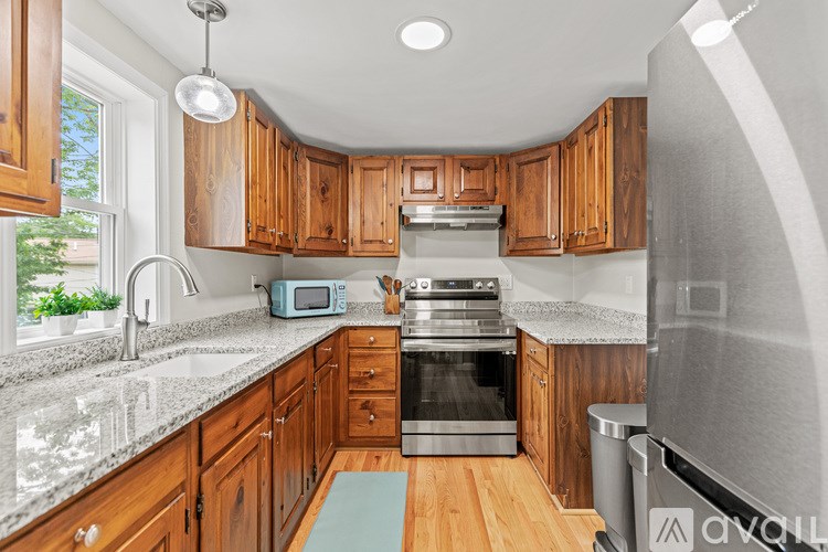 A kitchen with wooden cabinets and a granite countertop.
